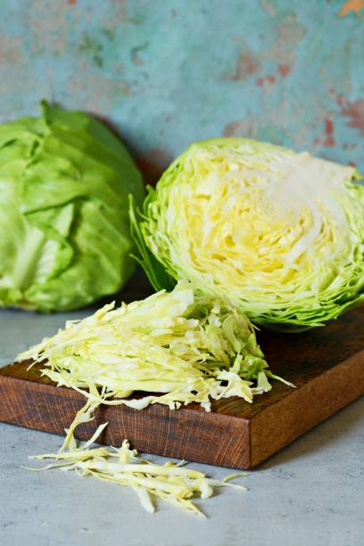 istock Fresh young cabbage on a wooden kitchen board for shredding on a blue background. Vegetables for cutting salad. Vegan food, diet, vitamins. 1214658664