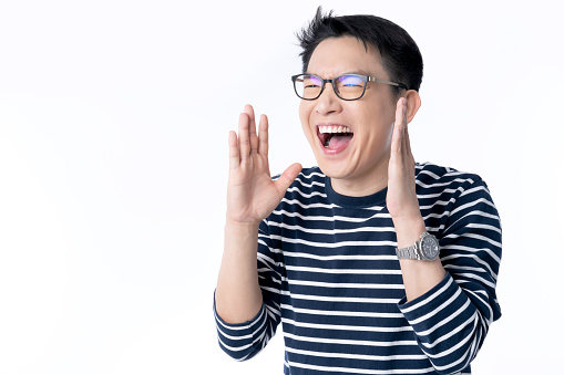 smart attractive asian glasses male hand rise up cheerful exited standing and smile with freshness and joyful casual blue shirt portrait white background