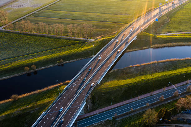 A viaduct bridge crossover a canal of highway A59 during sunrise near Waalwijk, Noord Brabant, Netherlands A viaduct bridge crossover a canal of highway A59 during sunrise near Waalwijk, Noord Brabant, Netherlands canal photos stock pictures, royalty-free photos & images