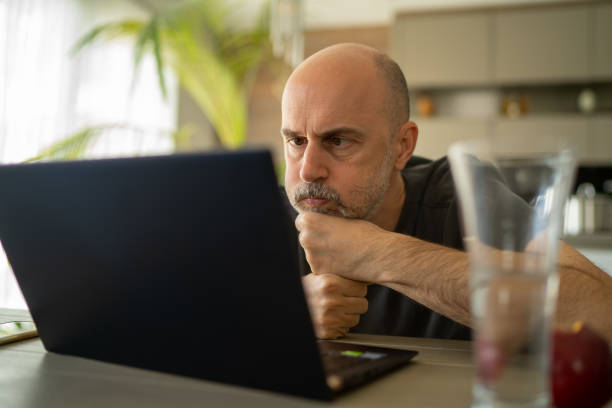 istock concerned manager businessman working from home at laptop during coronavirus crisis 1214661016