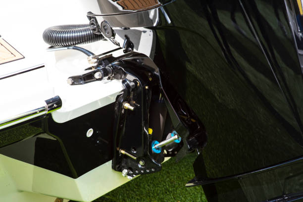 istock Side view of a new black motor boat engine without cowling on a blurred grassy beach background. Detailed closeup shoot. Outdoor sport, fishing, recreation and technical concept. 1214661489