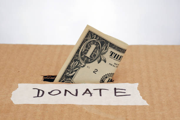 istock one dollar banknote inserted in a slot of donation box 1214663162