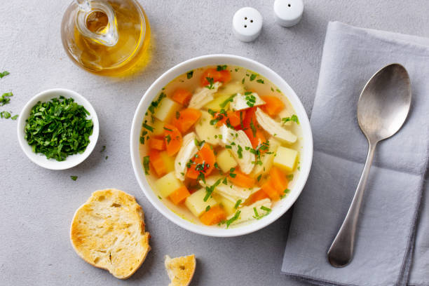 istock Chicken soup with vegetables in white bowl. Grey background. Top view. 1214668064