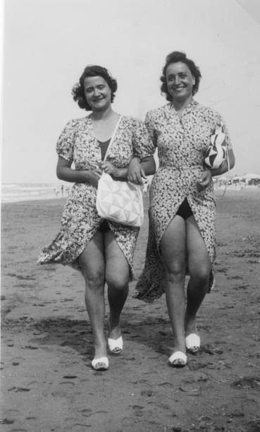1930s. alassio liguria italy. sisters at the beach - women cheerful vertical 20s imagens e fotografias de stock
