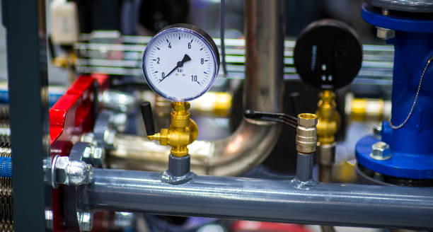 pressure gauge psi meter in pipe and valves of water system industrial focus left closeup white light defocus blur background pressure gauge psi meter in pipe and valves of water system industrial focus left closeup white light defocus blur background. psi stock pictures, royalty-free photos & images