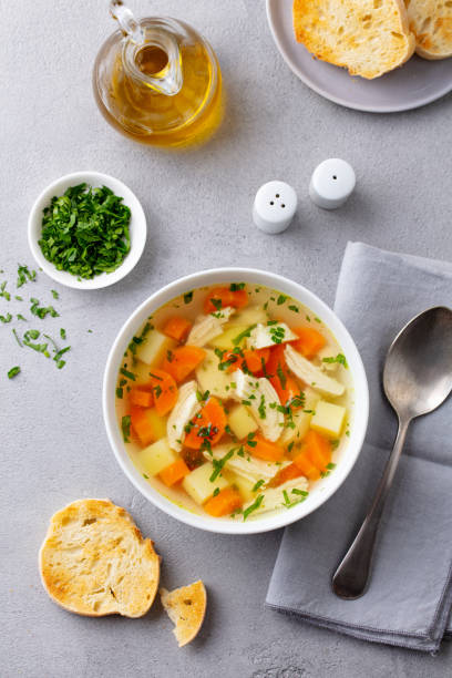 istock Chicken soup with vegetables in white bowl. Grey background. Top view. 1214671712