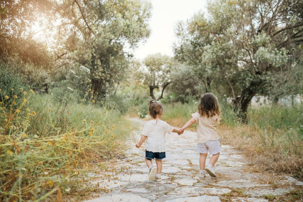 istock Two little girls having fun and running together 1214673238