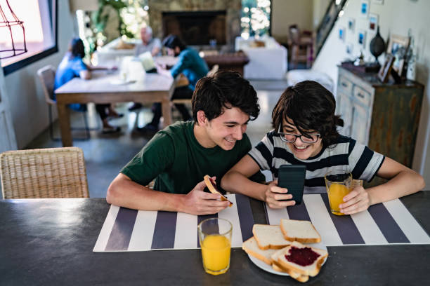 istock Teenagers having breakfast and using phone 1214673525