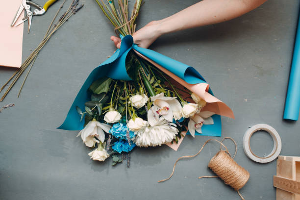 istock Florist makes a bouquet in a flower boutique on gray table top view 1214675253