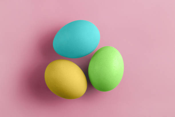 istock Three fresh coloured chicken eggs on a pink background. Minimal Happy Easter concept decoration. 1214679239