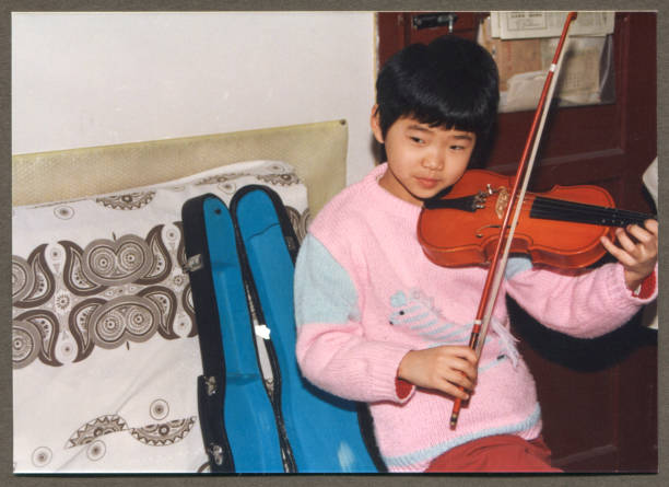 1990s Chinese Little girl practicing violin 1990s Chinese Little girl practicing violin korean ethnicity photos stock pictures, royalty-free photos & images