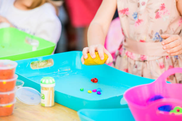 istock child sculpts figures from plasticine. development center. help children with disabilities. A pretty girl of three years old sits at the table and sculpts figures from colored clay. Sculpting and childrens creativity. 1214681788