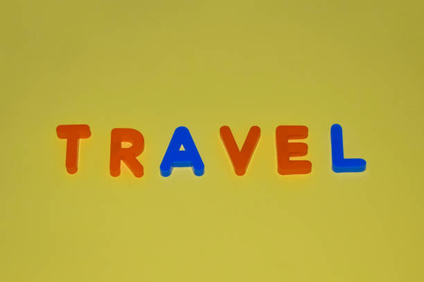 Travel word written with different colored letter blocks arranged on a yellow background