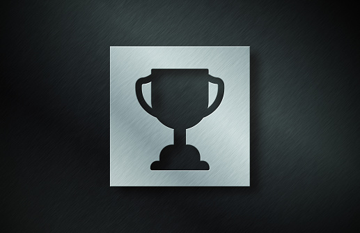 Gray Metal Plate With Trophy award Symbol On Dark Metallic Background. Horizontal composition with copy space.
