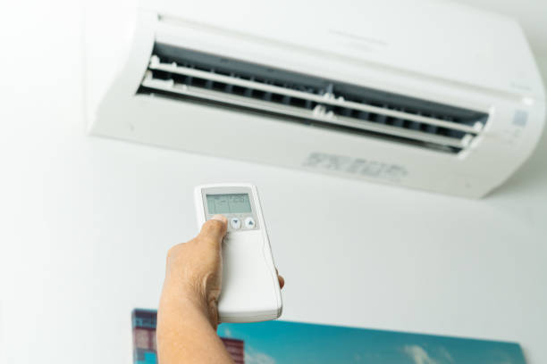 istock Remote control directed on air conditioner system, senior hand control air conditioner at home 1214686000