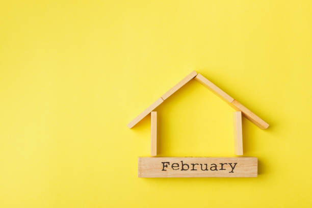 istock house shaped wooden logs on the yellow background 1214687320