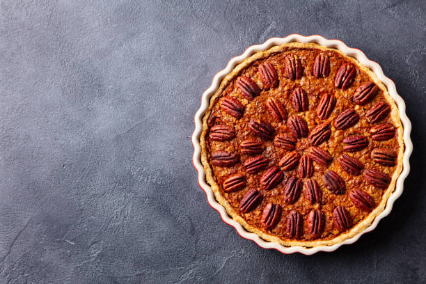 istock Pecan nut pie, tart in baking dish. Grey background. Copy space. Top view. 1214687662