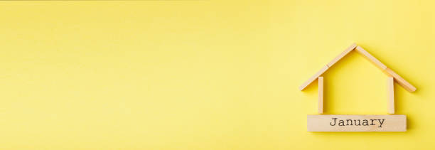 istock house shaped wooden logs on the yellow background 1214688799