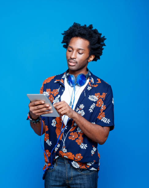 istock Confident man in hawaiian shirt using digital tablet 1214689452