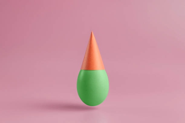 istock One green egg  in a red festive cap on a pink background. Minimal Happy Easter concept decoration. 1214690178