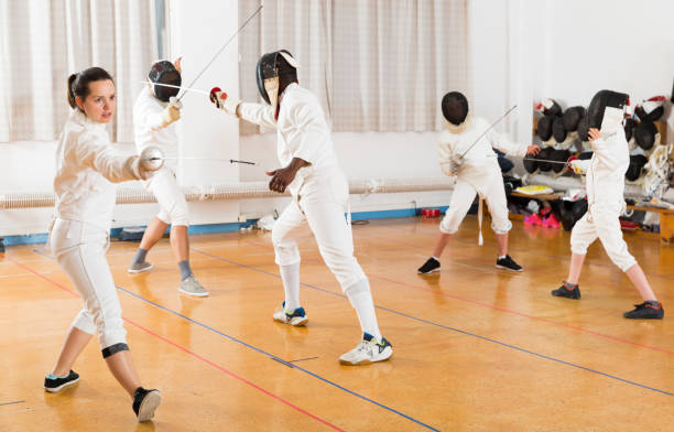 istock Woman wearing fencing uniform practicing with foil 1214690576