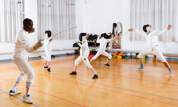 istock Coaches demonstrating to young athletes attack movements with rapier during fencing workout 1214690580