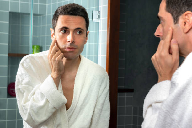 istock Middle aged man reviewing wrinkles in bathroom mirror. 1214691142