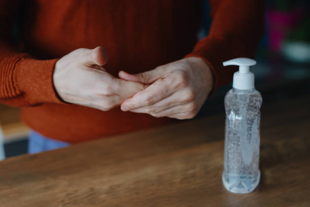 istock Man using hand sanitizer to clean his hands 1214691243