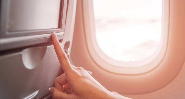istock Hand pressing button on the screen on in the airplane. Internet on the plane concept. 1214691282