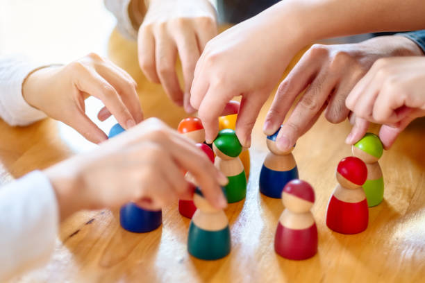 istock People choosing and picking up wooden figure from a group 1214691361