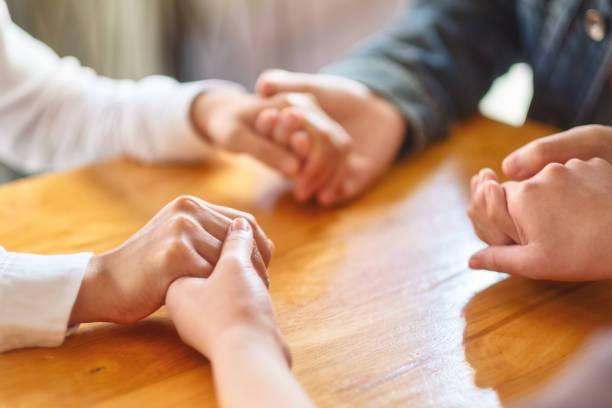 istock people sitting in a circle holding hands and pray together or in therapy session 1214691362