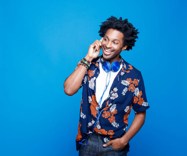 istock Funky young man in hawaiian shirt using smart phone 1214691969