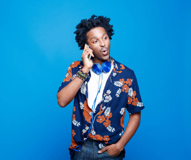 istock Funky young man in hawaiian shirt using smart phone 1214692265