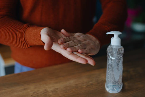 istock Man using hand sanitizer to clean his hands 1214692378