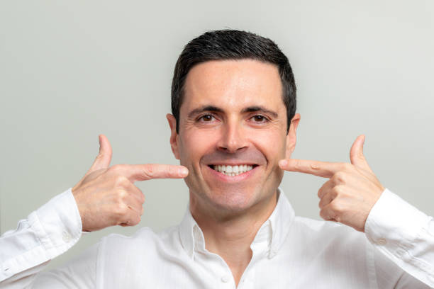 istock Middle aged man pointing at wrinkles along cheek. 1214692494