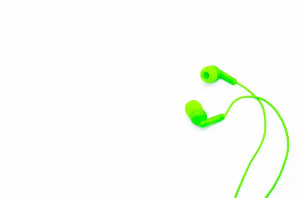 Green EarPods Basic In-Ear Headphone Earbuds on white background. Copy space