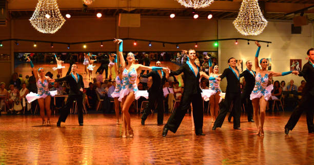 Couples Latin dancing Demonstration. Herent, Belgium - September 14, 2019: Open House indoor dancing classes evening show. Latin competition Dancers  demonstration. Four couples in view, ladies arms and hand up. drop earring stock pictures, royalty-free photos & images