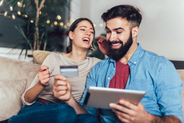 istock Smiling couple using digital tablet and credit card at home 1214694109