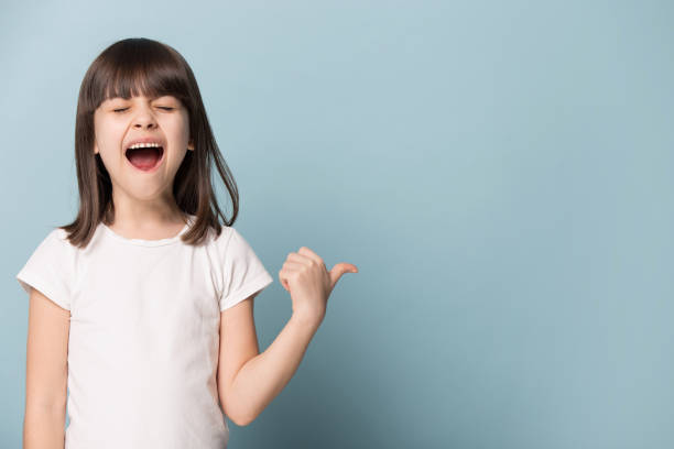 istock Cute little girl point at blank copy space announcing discounts 1214694491