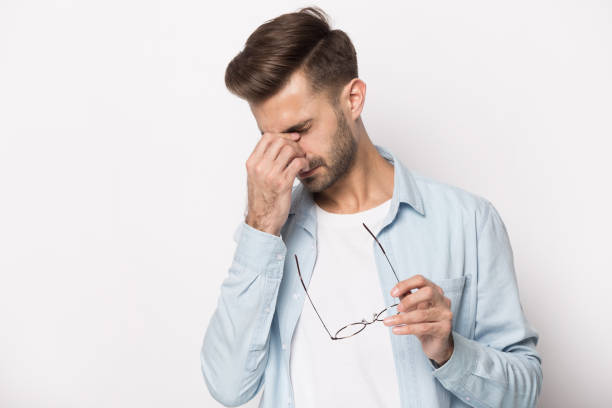 istock Tired millennial man take off glasses suffering from headache 1214694514
