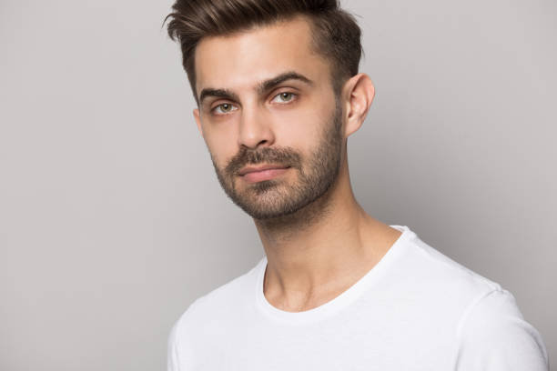 istock Close up of serious caucasian man posing on grey background 1214694537