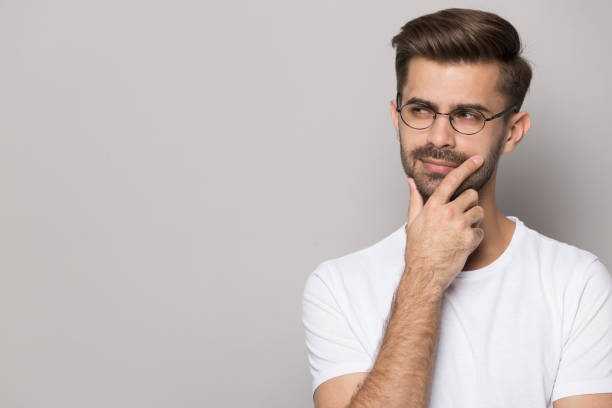 istock Pensive male in glasses look at copy space making decision 1214694541