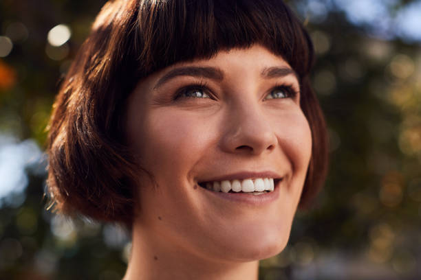 istock Young woman with a perfect complexion standing outside and smiling 1214695398