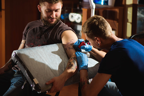 Tattooist makes a tattoo.