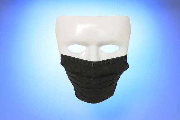 istock White death mask in black medical protective mask, on blue gradient background. Death from dangerous COVID-19 concept, 2019-nKoV or Covid-19. 1214697280