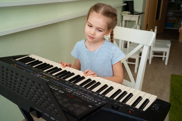 istock a little girl learns to play the synthesizer. 1214697938