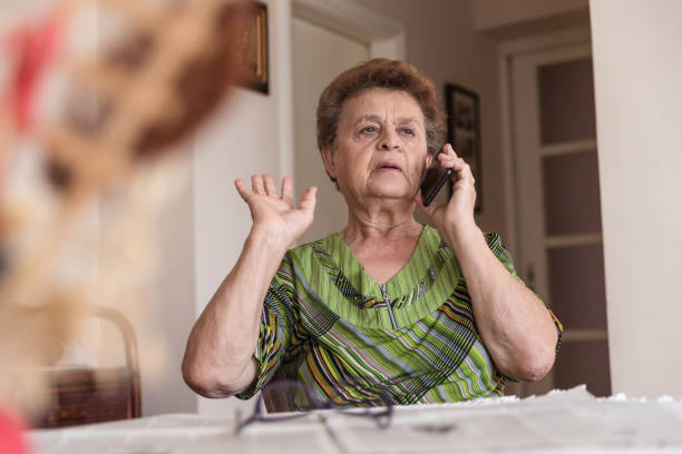 istock Upset mature woman talking on phone 1214698994