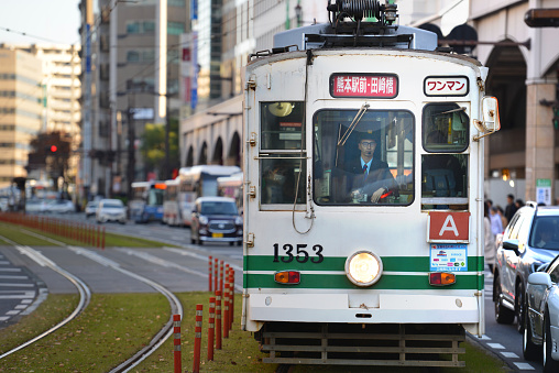 Iconic electric streetcar at the station on a sunny afternoon in Kumamoto, Japan