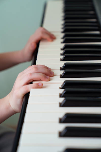 istock baby hands black white piano keys synth. close-up. 1214699689