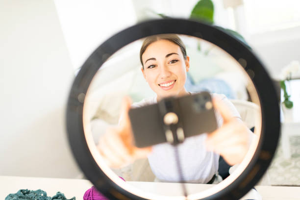 Young Woman Influencer setting up smart phone in ring light